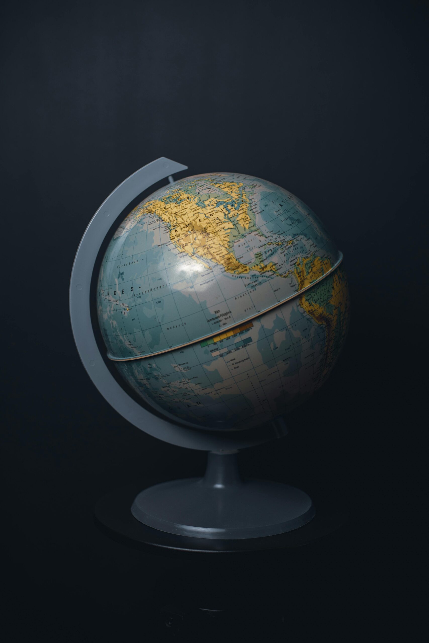 Home An antique world globe displayed on a dark black background, highlighting North America.